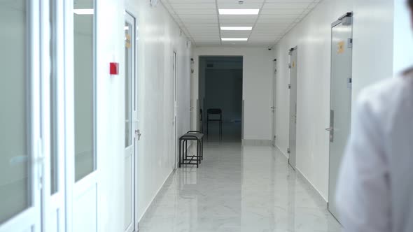 Hospital Corridor with Young Woman in Uniform Entering Walking Indoors