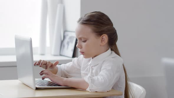 Diligent Caucasian Schoolgirl Working on Laptop in Class