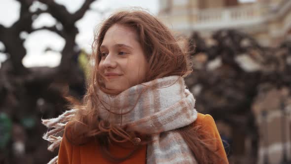 Portrait of Adorable Caucasian Woman Wearing Coat and Scarf Breathing Fresh Air While Standing on