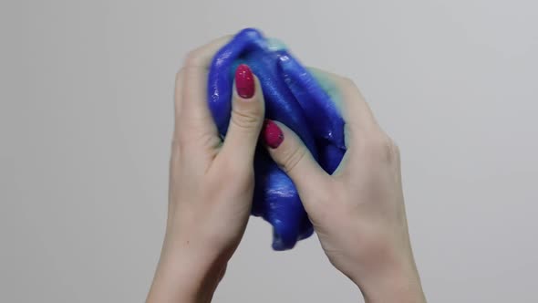 Woman Hands Playing with Oddly Satisfying Blue Slime Gooey Substance. Antistress