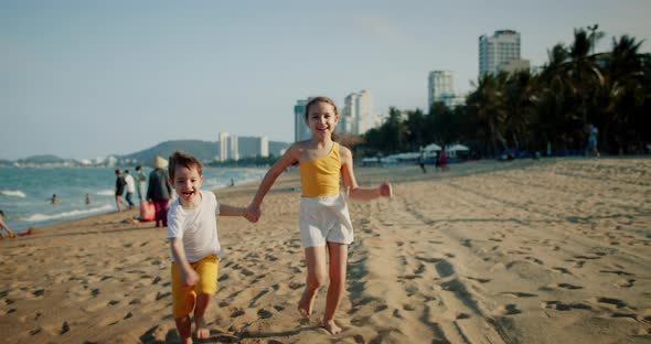 Happy Young Kids Running Down Beach Playing with Their Dog Family Beach Vacation