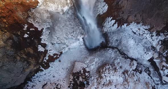 Birdseye view in flight over an ice fall in Iran. a river flow in a valley then fall from a cliff ma