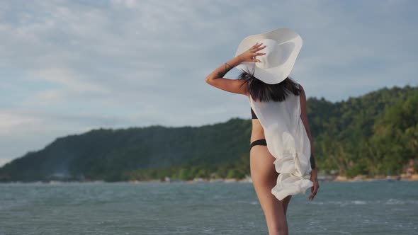 Young Woman In Thong And Sun Hat In Sea