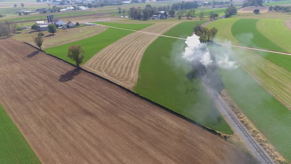 Antique Restored Steam Engine Traveling Thru Farmlands Blowing Smoke and Steam