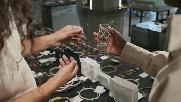 Seller Showing Earrings to Customer