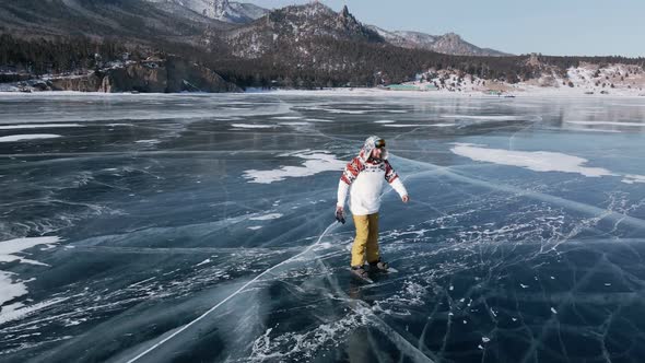 Aerial View of Man Skating on Lake Baikal Covered By Ice