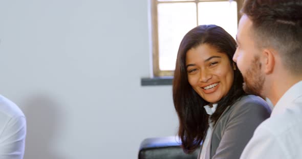 Couple discussing with broker on sofa in office 