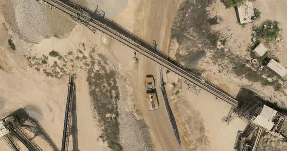 Fly over Rock and stone grinder and conveyor belt in a large quarry.