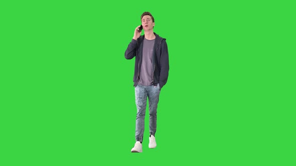 Happy Student Walking and Talking on Mobile Phone on a Green Screen, Chroma Key.