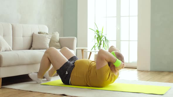 Plump Man Newcomer in Sport in Sportswear Doing Abs Crunch Exercise at Home