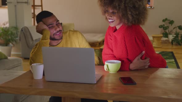 Millennial adult friends socialising together at home