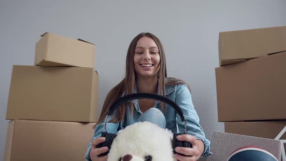 Joyful Woman which Fooling with Teddy Toy in Her New Flat After Moving