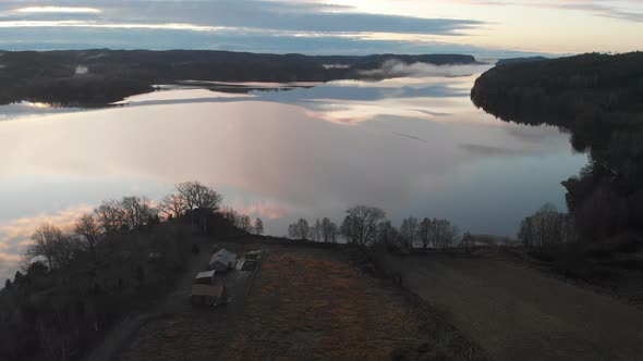 Clouds Reflection on Lake Surrounded By Forest Aerial Backward