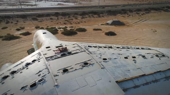 Aerial view woman doing exercise in the top of cargo airplane on Umm Al Quwain.