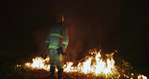 Portrait of Firefighter with Full Equipment Holds the Axe in His Hand