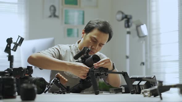 An Asian man is setting a camera rig