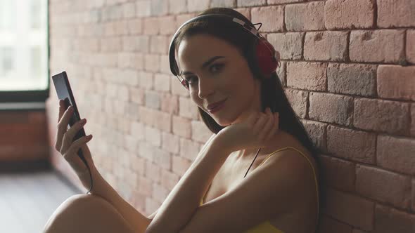 Woman Listening To Music Near Wall