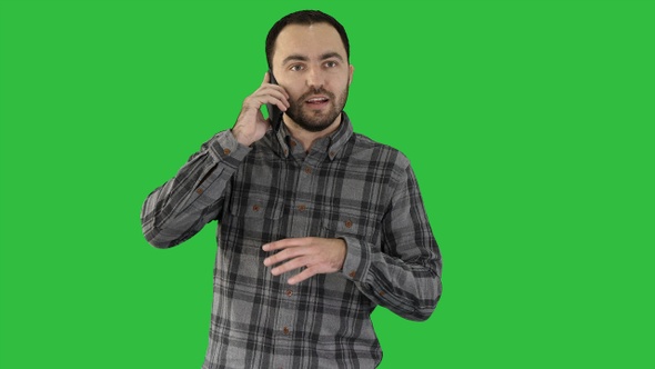 A man is talking on the phone and smiling on a Green Screen