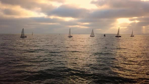 Flying over rolling waves towards sailboats