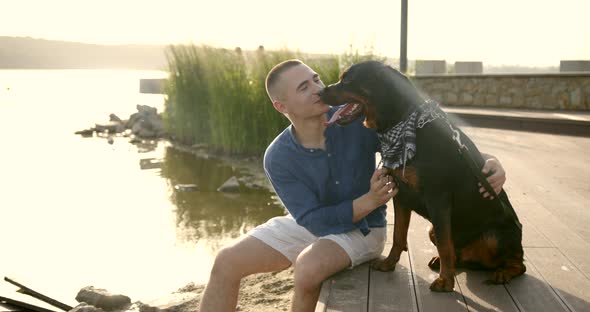 Young Man Spending Time with His Dog Be River Bank