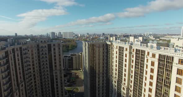 An Aerial View of a Large Modern Residential Building and a Sunny Urbanscape Behind It