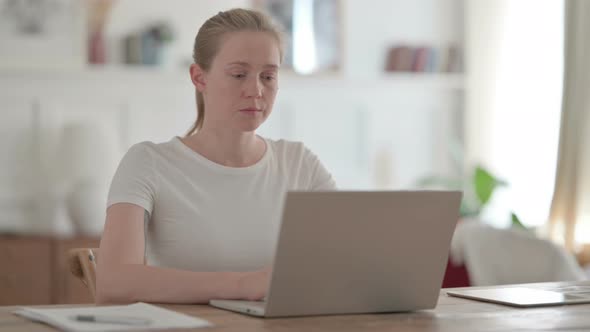 Beautiful Young Woman Working on Laptop in Office