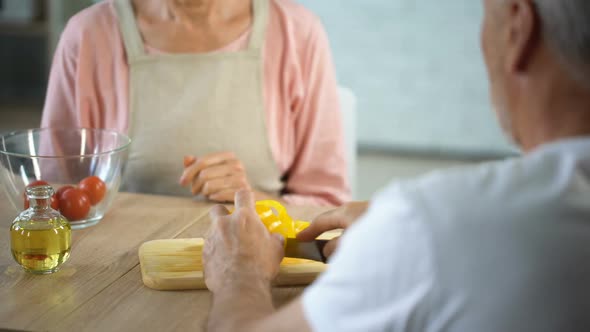 Playful Woman Making Faces With Pepper Slices, Senior Couple Having Fun at Home