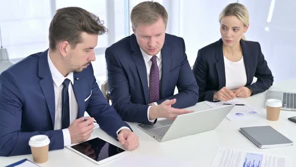 Ambitious Business Team Discussing Work on Laptop