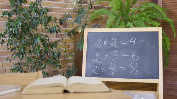 Empty Classroom with Chalkboard Desk and Textbook