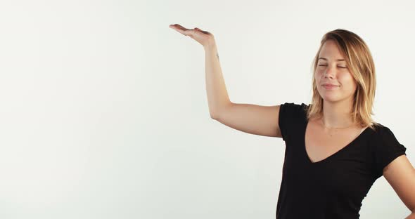 Young blond woman presenting something on white studio background