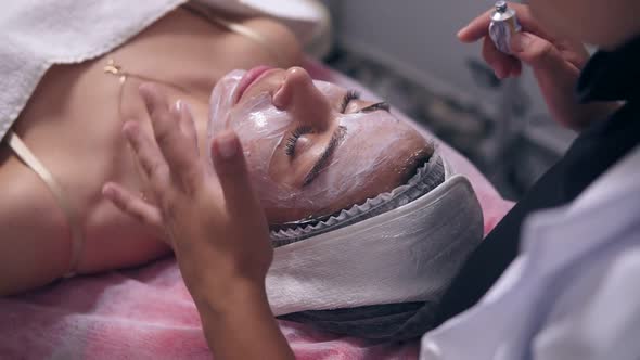 Closeup View of Young Woman Lying on the Couch While Professional Cosmetologist is Apllying Special