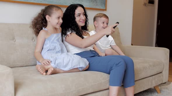 Happy Family, Mom and Cute Little Children Watch the TV, Mom Plays with Children at Home, Relaxing