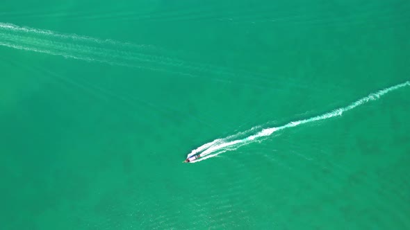 An aerial view of the boat sailing in the beautiful turquoise waters