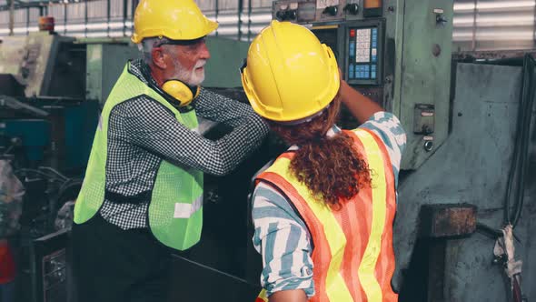 Group of Factory Workers Using Machine Equipment in Factory Workshop