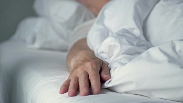 Caring Hand of a Nurse in Protective Gloves Holding the Hand of a Sick Person