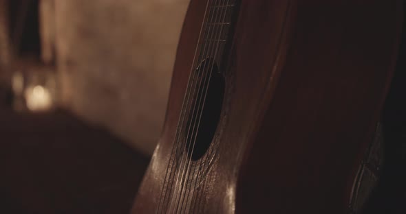 Wooden Acoustic Guitar's Body Leaning on a Concrete Wall