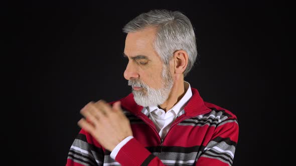 An Elderly Man Adjusts His Clothes and Smiles at the Camera - Black Screen Studio