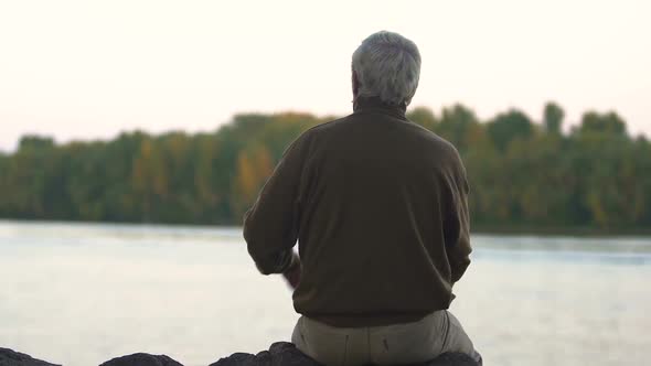 Sad Man Sitting on River Coast Thinking About Moments of His Life