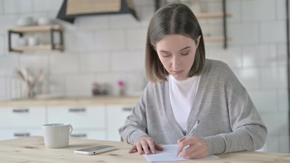 Ambitious Young Woman Working on Documents on Desk