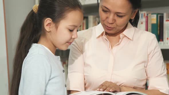 Mother and Daughter Choosing Books at the Library or Bookstore
