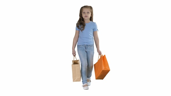 Little girl with shopping bags walking on white background.