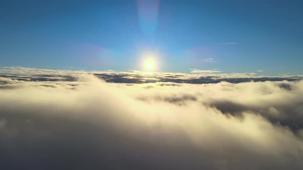 Aerial View From Airplane Window at High Altitude of Dense Puffy Cumulus Clouds Flying in Evening