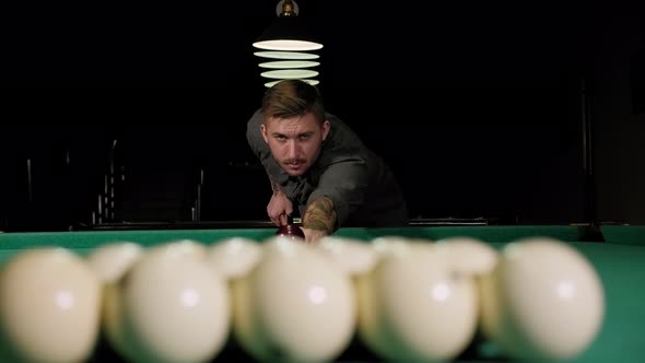 A Man Playing Billiards, He Takes Aim and Prepares To Hit the Balls with a Cue.