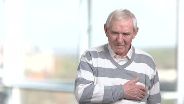 Unhappy Senior Massaging His Chest.