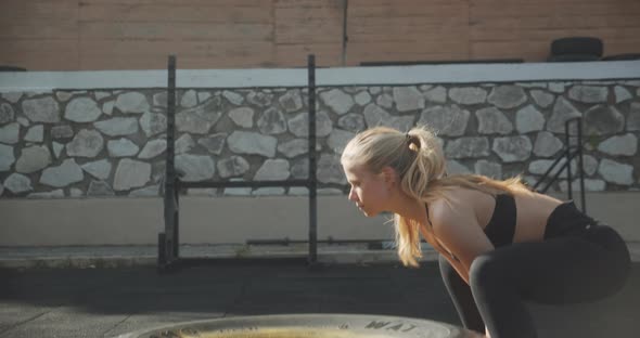 Athlete Lifting And Pushing Tire In Outdoor Gym