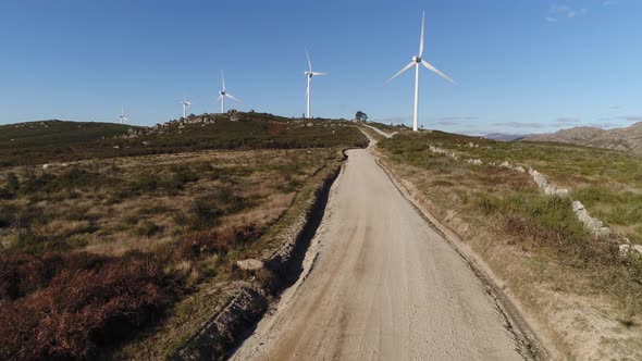 Dirty Road with Windmills on Mountains