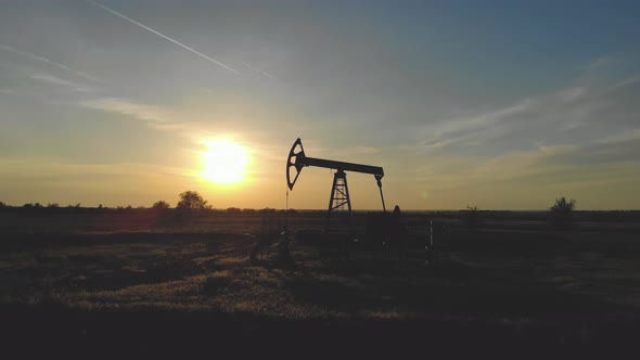 Silhouette of Working Oil Pump From Oil Field at Sunset. The Industrial Equipment.