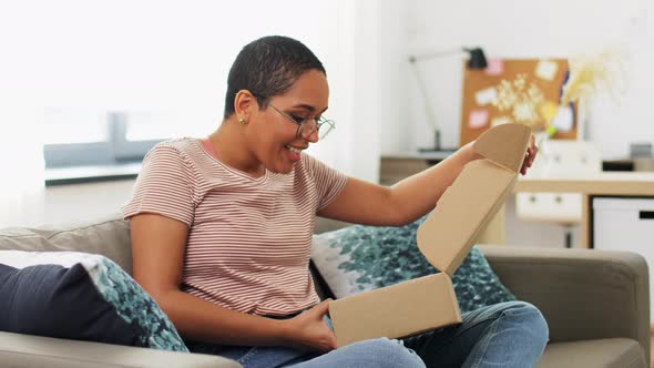 African American Woman Opening Parcel Box at Home