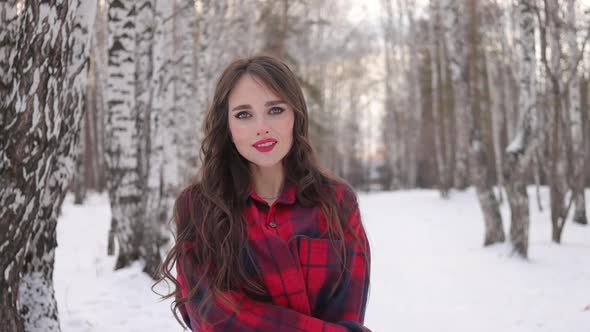 Charming Female with Long Hair Walking in Snowy Forest