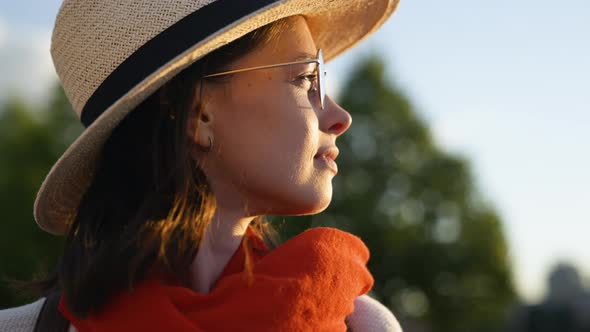 Attractive young woman with red scarf looking at the sun, close-up